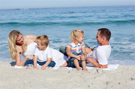 Happy family sitting on the sand at the beach Photographie de stock - Aubaine LD & Abonnement, Code: 400-04188966