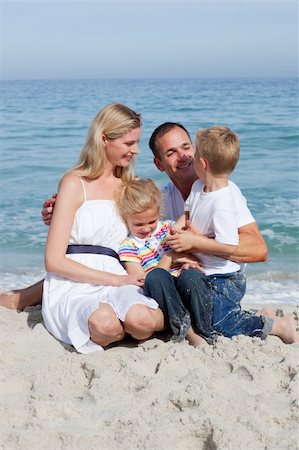 Cute children and their parents sitting on the sand at the beach Stock Photo - Budget Royalty-Free & Subscription, Code: 400-04188967