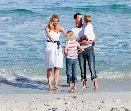 Happy family sitting on the sand at the beach Photographie de stock - Aubaine LD & Abonnement, Code: 400-04188976