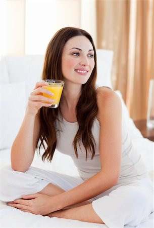 simsearch:400-03998265,k - Beautiful woman drinking orange juice sitting on bed at home Fotografie stock - Microstock e Abbonamento, Codice: 400-04188983