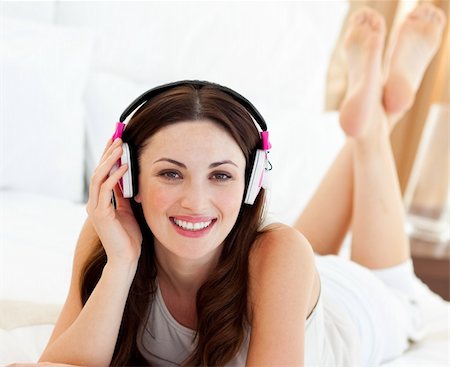 simsearch:6109-06194973,k - Beautiful woman listening music lying on bed at home Foto de stock - Super Valor sin royalties y Suscripción, Código: 400-04188997