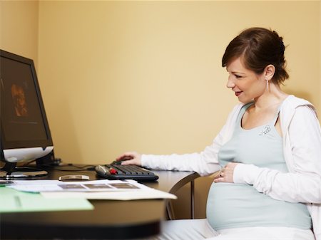 simsearch:400-06567245,k - italian 6 months pregnant woman watching ultrasound pictures of her baby on desktop computer at home. Horizontal shape, side view, copy space Stockbilder - Microstock & Abonnement, Bildnummer: 400-04189211