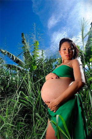 Woman is outdoor in the jungle and holds her pregnant stomach Foto de stock - Super Valor sin royalties y Suscripción, Código: 400-04181102
