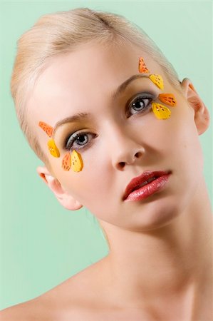 portrait of pretty and young blond woman with colored creative make up on green background Photographie de stock - Aubaine LD & Abonnement, Code: 400-04181178