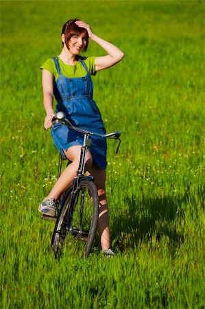 simsearch:400-04201795,k - Happy young woman with a vintage bicycle on a green meadow Fotografie stock - Microstock e Abbonamento, Codice: 400-04181986