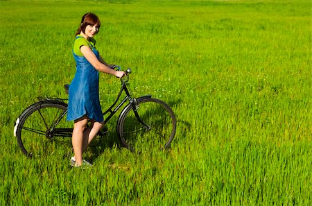 simsearch:400-04201795,k - Happy young woman with a vintage bicycle on a green meadow Fotografie stock - Microstock e Abbonamento, Codice: 400-04181982