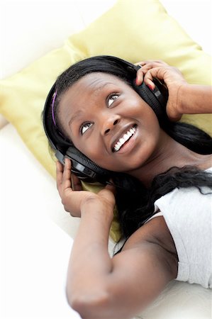 simsearch:400-05717354,k - Joyful woman listening music with headphones lying on a sofa in the living-room Stock Photo - Budget Royalty-Free & Subscription, Code: 400-04182964