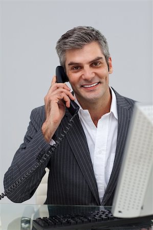 simsearch:400-04782151,k - Smiling mature male executive talking on phone at his desk Photographie de stock - Aubaine LD & Abonnement, Code: 400-04183255