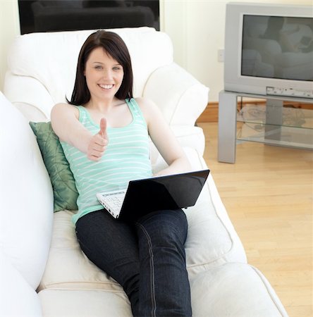 simsearch:400-04709946,k - Cheerful woman surfing the internet with a thumb up lying on a sofa at home Stockbilder - Microstock & Abonnement, Bildnummer: 400-04183499