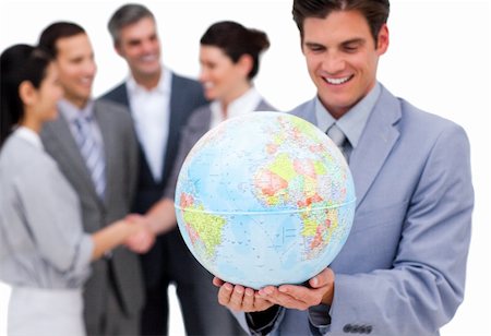 Cheerful businessman holding a globe in front of his team against a white background Stock Photo - Budget Royalty-Free & Subscription, Code: 400-04183687