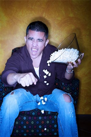 Male Hispanic sports fan with popcorn watching television Stock Photo - Budget Royalty-Free & Subscription, Code: 400-04194122