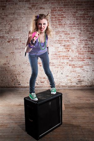 simsearch:400-04197211,k - Young punk rocker on a speaker in front of a brick background Foto de stock - Super Valor sin royalties y Suscripción, Código: 400-04194234