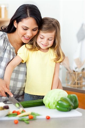 Adorable little girl cutting vegetables with her mother in the kitchen Stock Photo - Budget Royalty-Free & Subscription, Code: 400-04195241