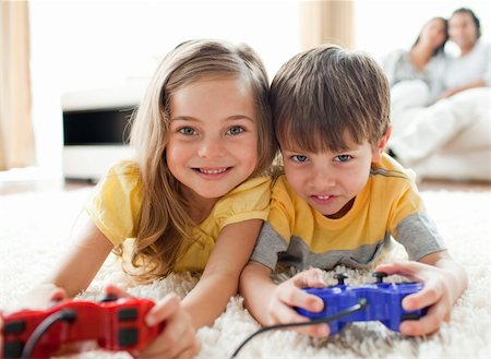 Adorable siblings playing video game in the living room Stock Photo - Budget Royalty-Free & Subscription, Code: 400-04195261
