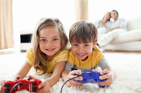 simsearch:400-04199147,k - Loving siblings playing video game in the living room Foto de stock - Royalty-Free Super Valor e Assinatura, Número: 400-04195262