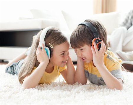 simsearch:400-04200290,k - Siblings playing on the floor with headphones in the living room Stock Photo - Budget Royalty-Free & Subscription, Code: 400-04195275