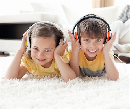 simsearch:400-04200290,k - Smiling siblings listening music with headphones lying on the floor Stock Photo - Budget Royalty-Free & Subscription, Code: 400-04195272