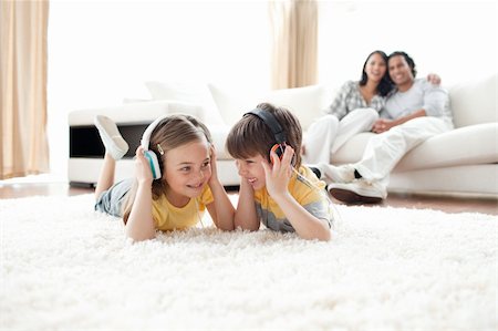 Brother and sister listening music with headphones lying on the floor Stock Photo - Budget Royalty-Free & Subscription, Code: 400-04195273