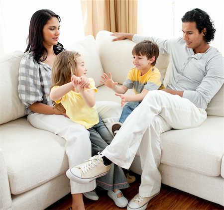 simsearch:400-04192370,k - Lively family having fun in the living room sitting on sofa Fotografie stock - Microstock e Abbonamento, Codice: 400-04195286
