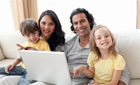 simsearch:400-04575374,k - Jolly family using laptop on sofa in the living room Stock Photo - Budget Royalty-Free & Subscription, Code: 400-04195280