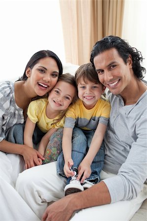 simsearch:400-04192370,k - Close-up of a smiling family sitting on sofa at home Fotografie stock - Microstock e Abbonamento, Codice: 400-04195283