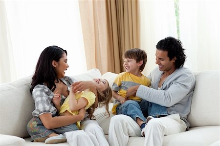 simsearch:400-04192370,k - Earing parents playing with their children on sofa at home Fotografie stock - Microstock e Abbonamento, Codice: 400-04195292