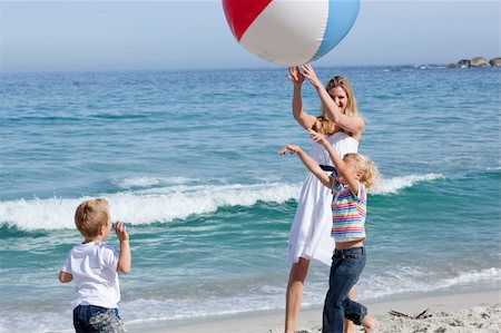 simsearch:400-04221909,k - Cheerful mother and her children playing with a ball at the beach Fotografie stock - Microstock e Abbonamento, Codice: 400-04195335