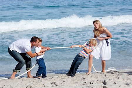 people playing tug war outside with family - Cheerful family playing tug of war at the beach Stock Photo - Budget Royalty-Free & Subscription, Code: 400-04195350