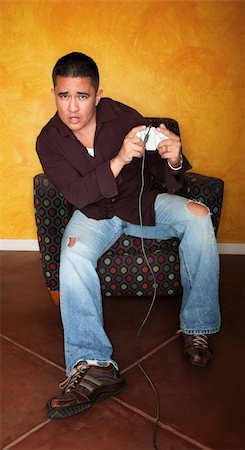 simsearch:400-04173797,k - Handsome Hispanic man playing Video game Stock Photo - Budget Royalty-Free & Subscription, Code: 400-04195517