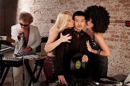 Asian DJ with fangirls kissing his cheek Foto de stock - Super Valor sin royalties y Suscripción, Código: 400-04195521
