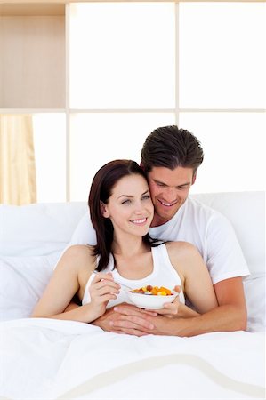 Smiling couple having breakfast lying in the bed Stock Photo - Budget Royalty-Free & Subscription, Code: 400-04195605