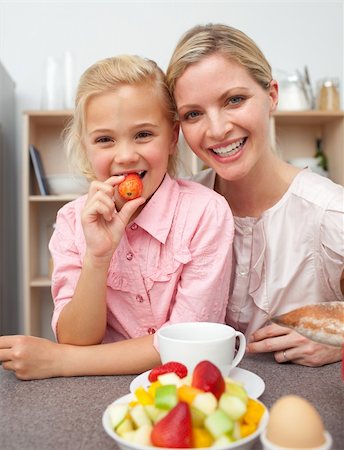 simsearch:400-04206231,k - Attentive mother eating fruit with her daughter in the kitchen Stock Photo - Budget Royalty-Free & Subscription, Code: 400-04195674