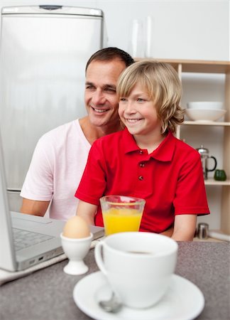 family eating computer - Happy father and his son having breakfast in the kitchen Stock Photo - Budget Royalty-Free & Subscription, Code: 400-04195676