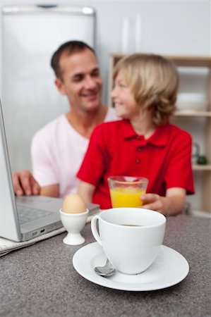 family eating computer - Jolly father and his son having breakfast in the kitchen Stock Photo - Budget Royalty-Free & Subscription, Code: 400-04195678