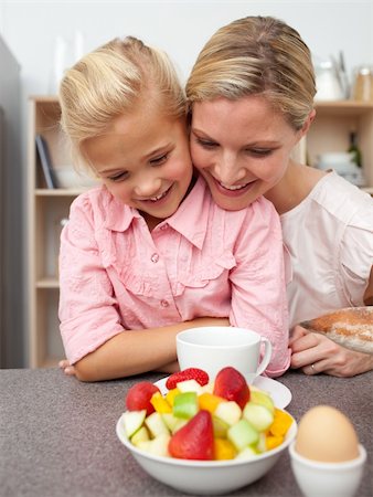 simsearch:400-04206231,k - Adorable little girl eating fruit with her mother in the kitchen Stock Photo - Budget Royalty-Free & Subscription, Code: 400-04195686