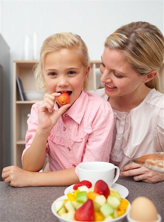 simsearch:400-04206231,k - Attractive mother eating fruit with her daughter in the kitchen Stock Photo - Budget Royalty-Free & Subscription, Code: 400-04195687