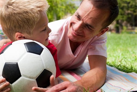 Close-up of an attentive father and his son holding a soccer ball in a park Stock Photo - Budget Royalty-Free & Subscription, Code: 400-04195743
