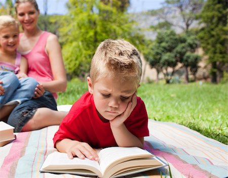 simsearch:400-04195786,k - Serious little boy reading while having a picnic with his family in a park Foto de stock - Royalty-Free Super Valor e Assinatura, Número: 400-04195768