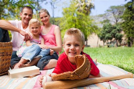 Smiling little boy wearing a baseball glove while having a picnic with his family in a park Stock Photo - Budget Royalty-Free & Subscription, Code: 400-04195777