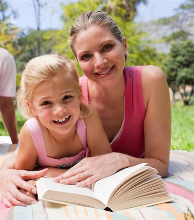 simsearch:400-04195786,k - Happy mother and her daughter reading at a picnic in a park Foto de stock - Royalty-Free Super Valor e Assinatura, Número: 400-04195787