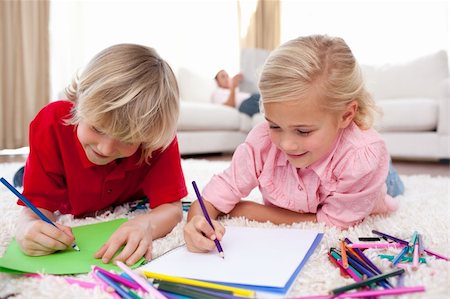 Concentrated children drawing lying on the floor in the living-room Stock Photo - Budget Royalty-Free & Subscription, Code: 400-04195816