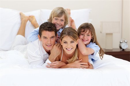 simsearch:400-04196942,k - Cheerful family having fun together lying on a bed Photographie de stock - Aubaine LD & Abonnement, Code: 400-04195913