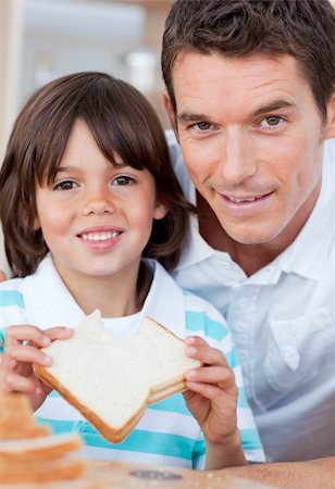 Portrait of a little boy and his father eating bread in the kitchen Stock Photo - Budget Royalty-Free & Subscription, Code: 400-04195977