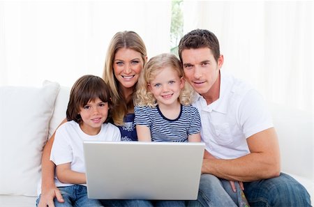 Portrait of a joyful family using a laptop sitting on sofa at home Stock Photo - Budget Royalty-Free & Subscription, Code: 400-04196004