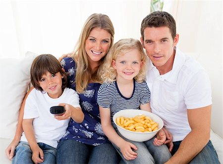 simsearch:400-05195435,k - Loving family watching television sitting on sofa at home Stockbilder - Microstock & Abonnement, Bildnummer: 400-04196011