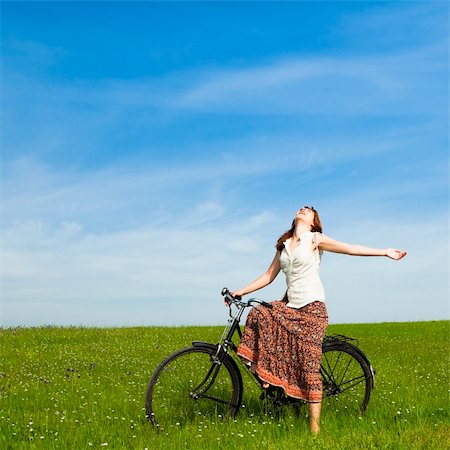 simsearch:400-04201795,k - Happy young woman with a vintage bicycle on a green meadow Fotografie stock - Microstock e Abbonamento, Codice: 400-04196129