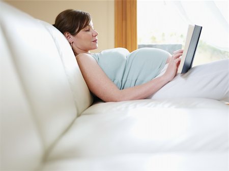 pregnant mom reading - italian 7 months pregnant woman lying down on sofa and reading book. Horizontal shape, side view, Copy space Stock Photo - Budget Royalty-Free & Subscription, Code: 400-04196865