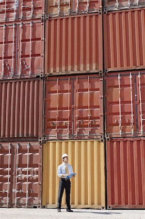 people warehouse freight - portrait of mid adult businessman standing near cargo containers and holding clipboard. Vertical shape, full length Photographie de stock - Aubaine LD & Abonnement, Code: 400-04196869