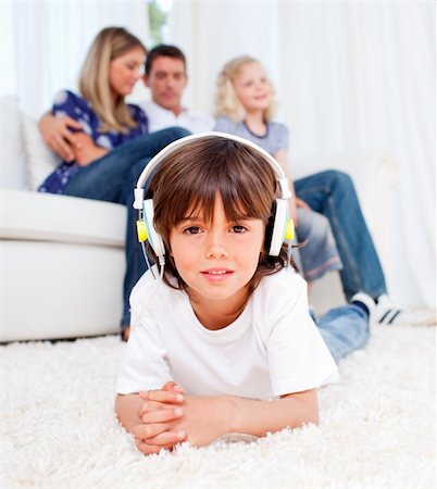 Cute little boy listening music lying on floor in the living room Stock Photo - Budget Royalty-Free & Subscription, Code: 400-04196883