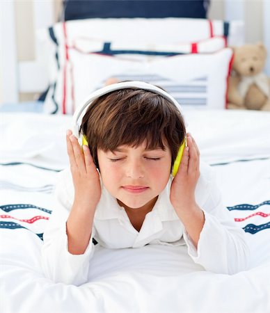 simsearch:400-04152181,k - Adorable little boy listening music with headphones on lying on his bed Stock Photo - Budget Royalty-Free & Subscription, Code: 400-04196930
